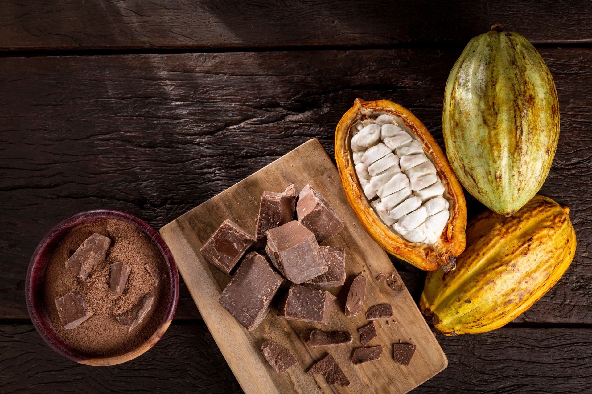 Cocoa with chocolate pieces and chocolate powder on the table.